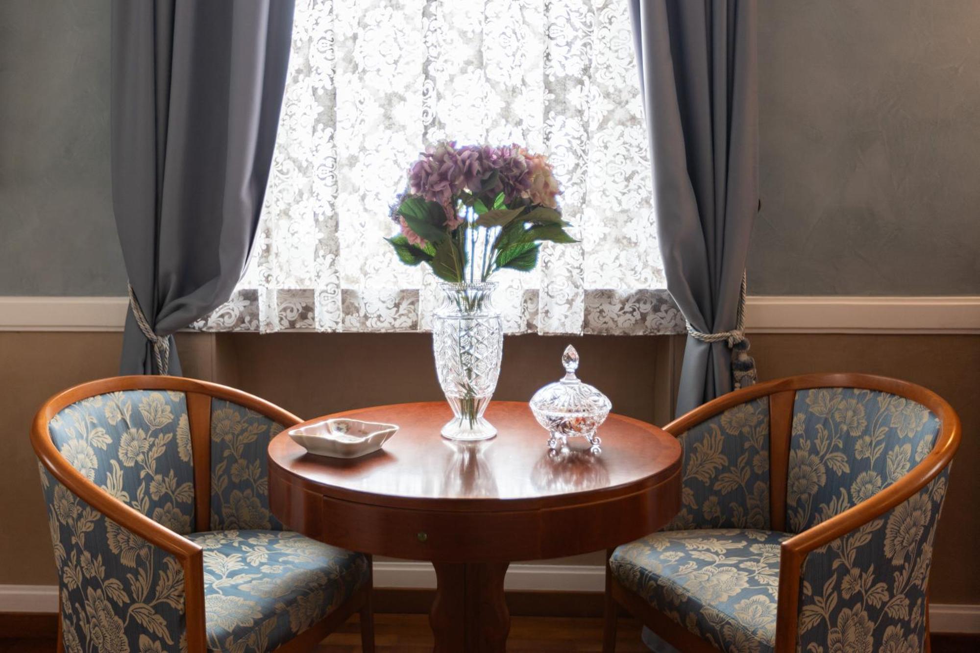 Grand Hotel Ortigia Syracuse Esterno foto A table with a vase of flowers